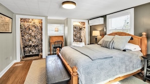 A bedroom with a large bed, a desk, and a walk-in closet.