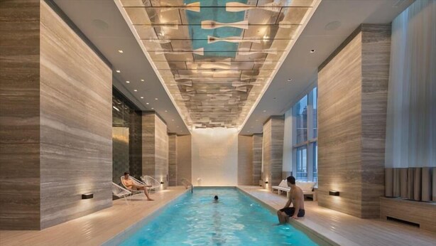 Ein hallenbad mit modernem Design, inklusive eines einzigartigen Muster im Deckenbereich und Holzwänden.
