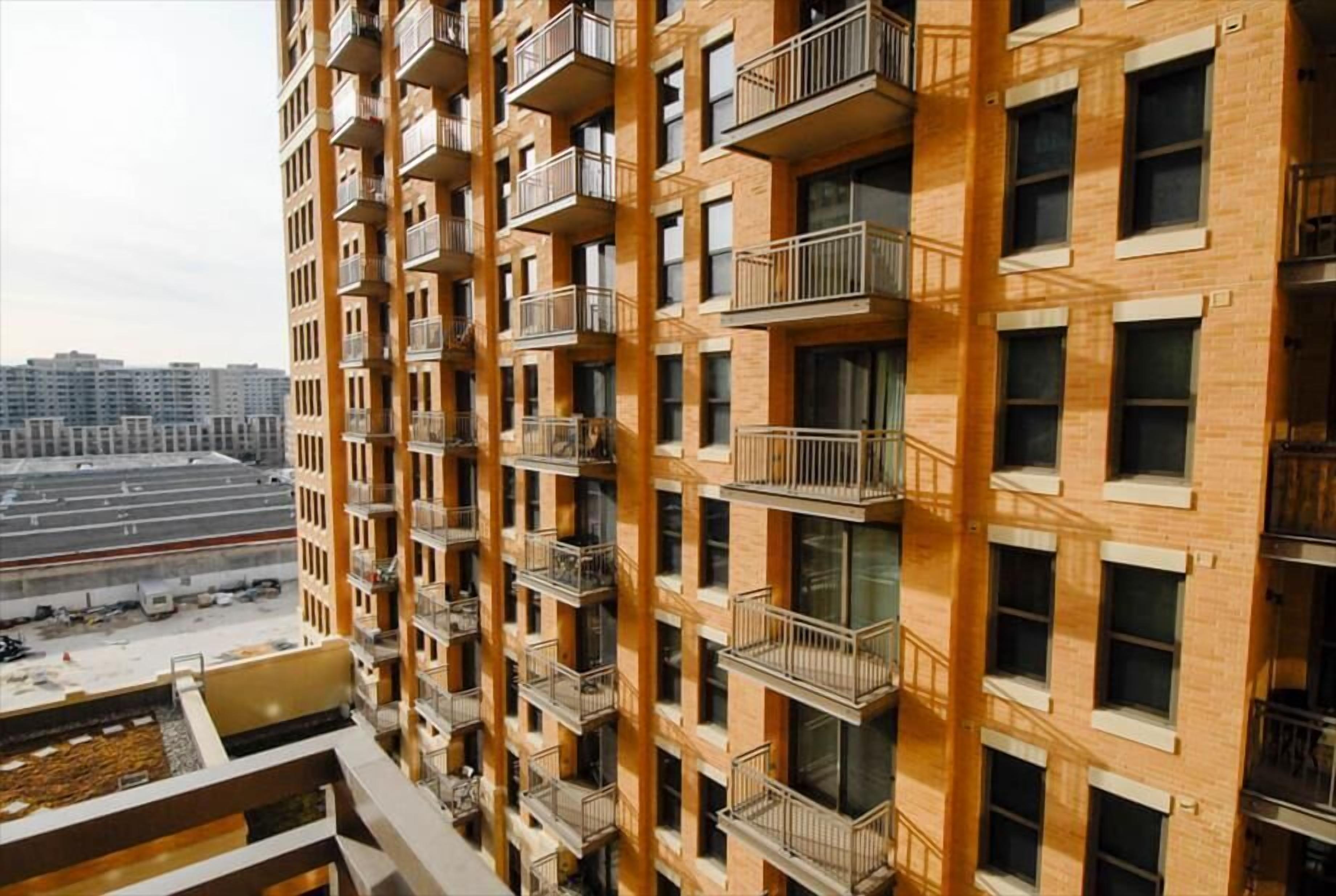 A multi-story residential building with balconies and large windows.