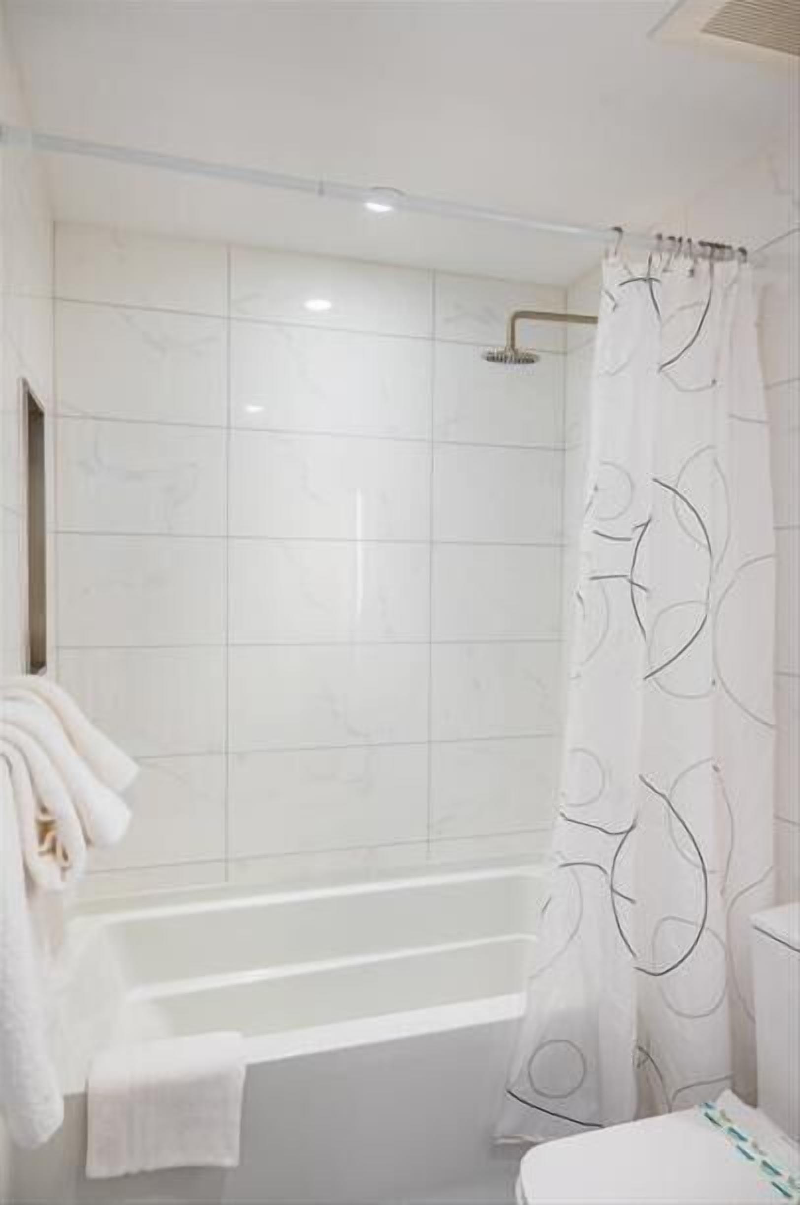 Un baño moderno con bañera, ducha e inodoro.