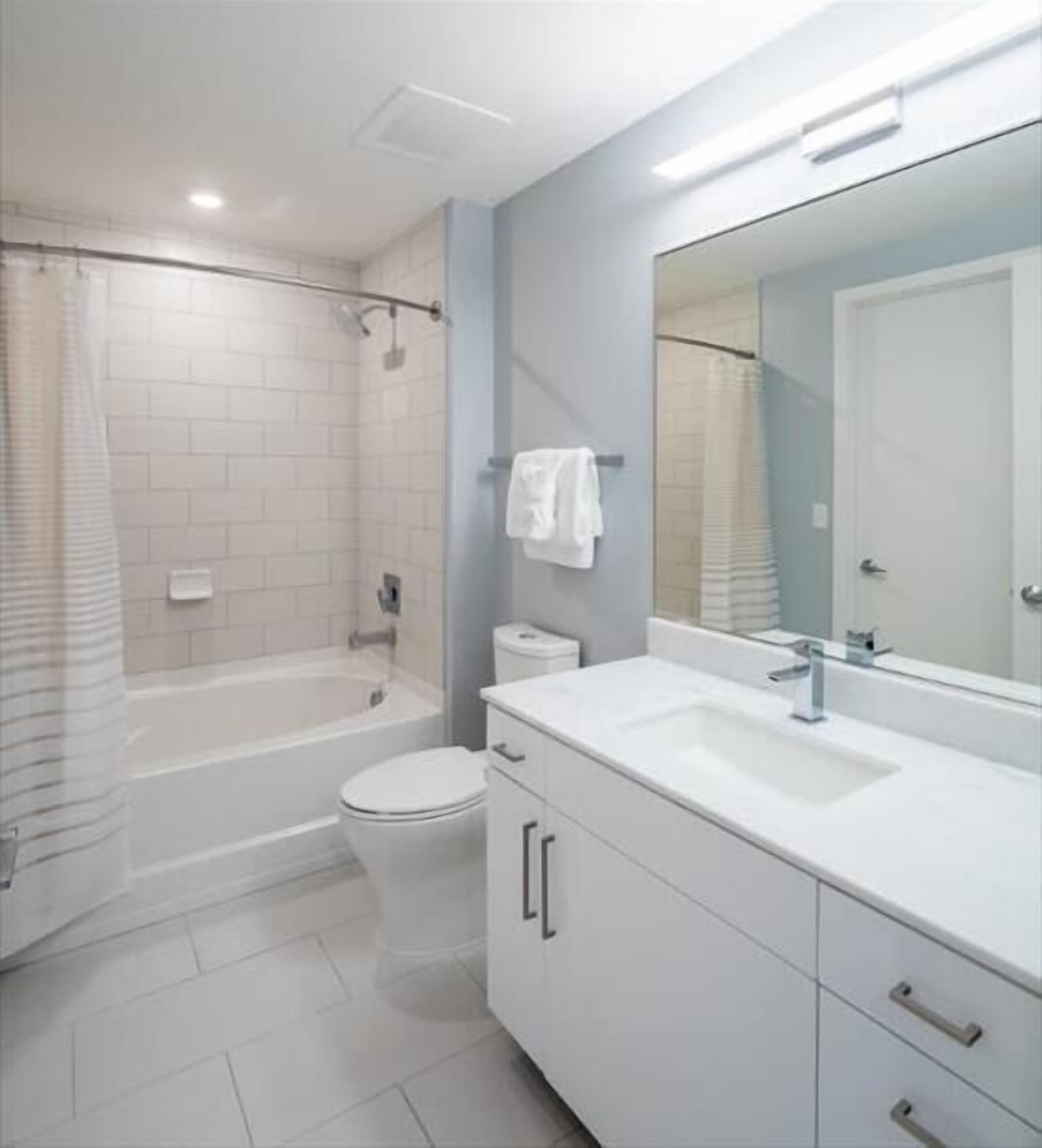 Un bagno moderno con vasca, water e lavabo.