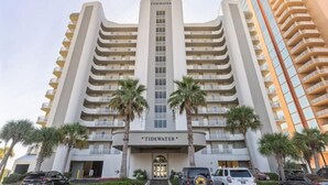 A multi-story hotel with a central entrance, palm trees in front, and a clear sky. - 3 Bedrooms and 3 baths : Beach Facing Condo (Orange Beach)