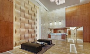 Eine moderne Lobby mit Empfangstresen, Sitzgelegenheiten und einem Marmorboden.