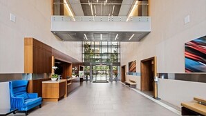A spacious lobby with a reception desk, seating area, and a large glass entrance. - Crystal City 1 BR | 10 min drive to Capitol (Arlington)