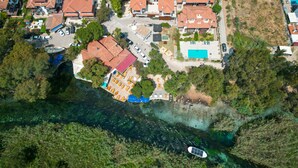 An aerial view of a coastal residential area with houses, a swimming pool, and a beach. - Akyaka Nehir Butik Otel (Ula)
