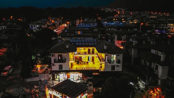 A two-story building with a balcony and a ground-level shop. - Akyaka Nehir Butik Otel (Ula)