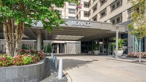Ein modernes Gebäude mit überdachter Eingangstür, auf der "MONACO" steht.