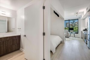 Eine moderne Wohnung mit Badezimmer, Schlafzimmer und Küchenzeile.