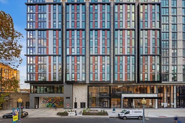 Een modern meerlaags gebouw met een gevel van glas en gepatteerde panelen.