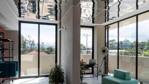 A spacious living area with a glass floor, large windows, and a balcony with a view.