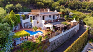 A villa with a swimming pool, outdoor seating, and a stone wall. - YourHome - Villa Mia (Massa Lubrense)