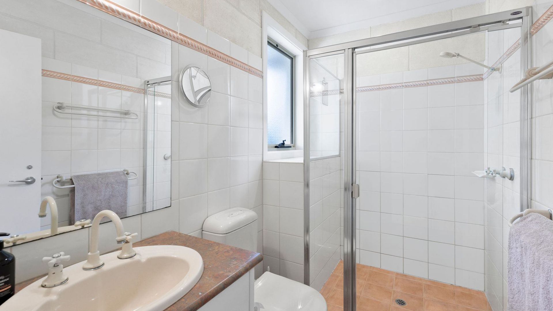 Ein Badezimmer mit Waschbecken, Toilette und Duschkabine.