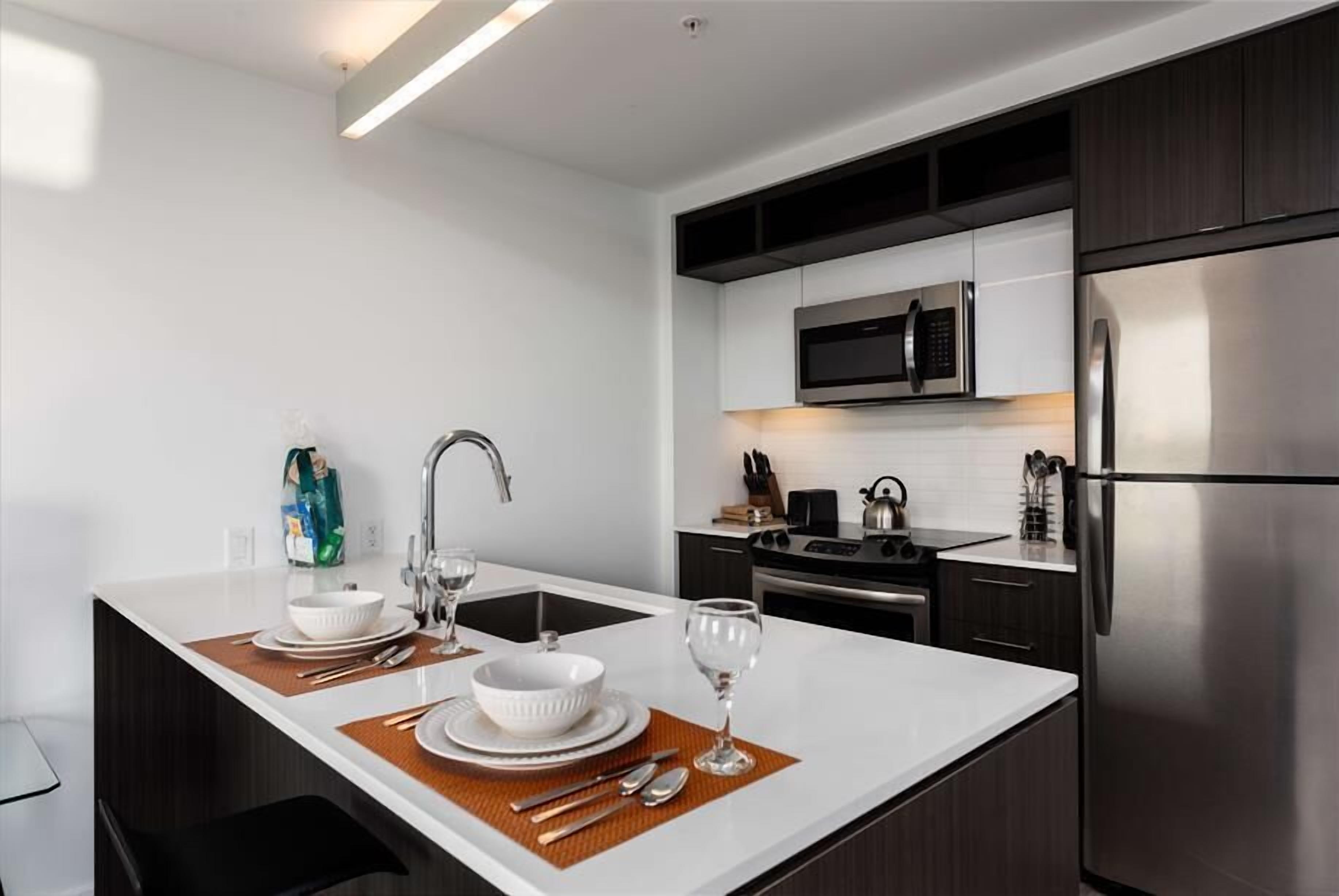A modern kitchen with a central island, stainless steel appliances, and a microwave above the stove.