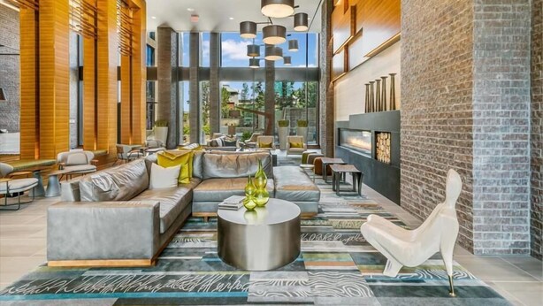 A modern lounge area with a sofa set, round coffee table, and a fireplace.