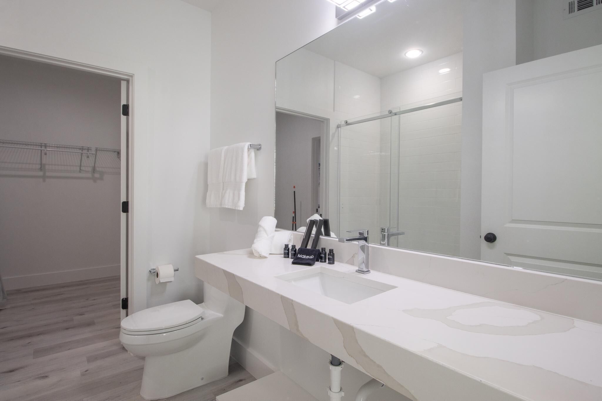Ein modernes Badezimmer mit Waschbecken, Spiegel und Toilette in Weiß.