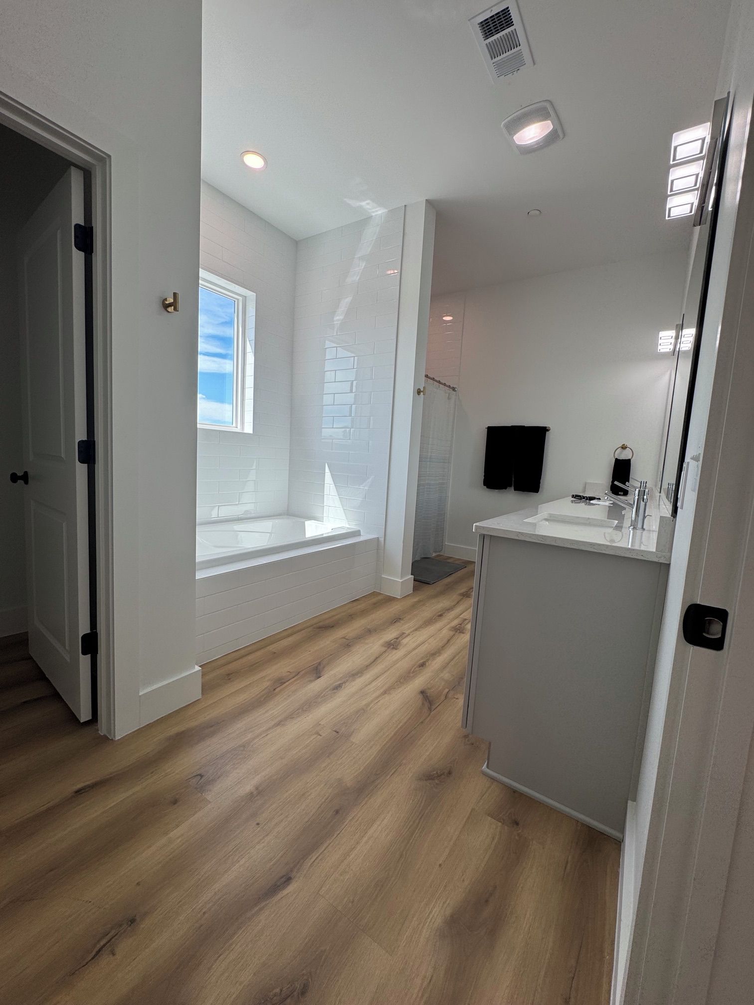 A bathroom with a bathtub, a sink, and a mirror.