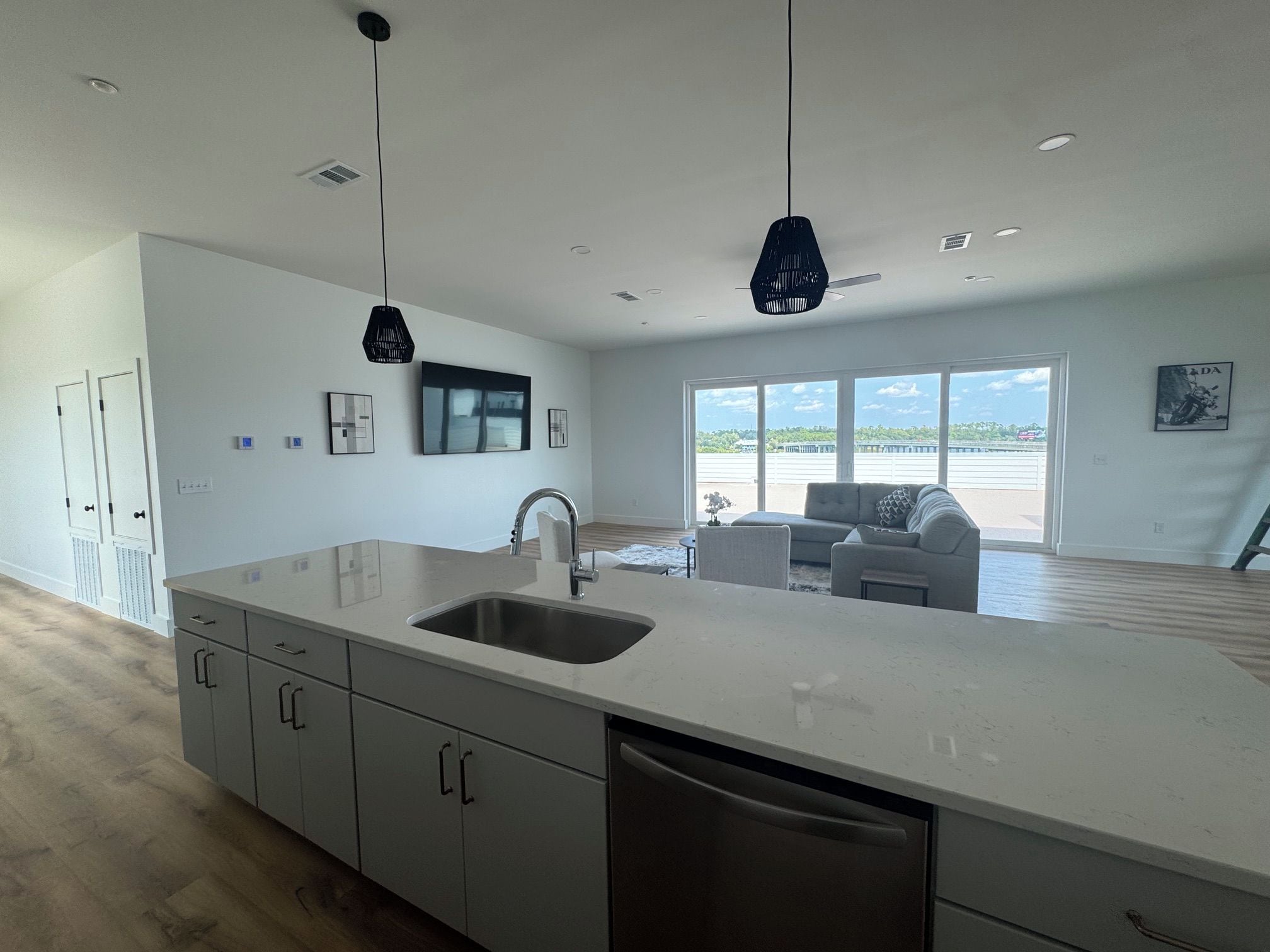 A modern kitchen with a large island, built-in cabinets, and a dishwasher.