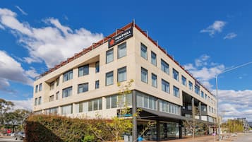 A modern building with a sign for 'PUNTHILL APARTMENT HOTEL'.