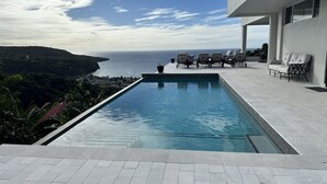 A modern infinity pool with a clear view of the ocean and a hillside. - Belle La Maye - Triton (Castries)