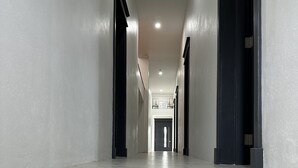 A long, narrow hallway with a tiled floor and white walls. - Belle La Maye - Triton (Castries)