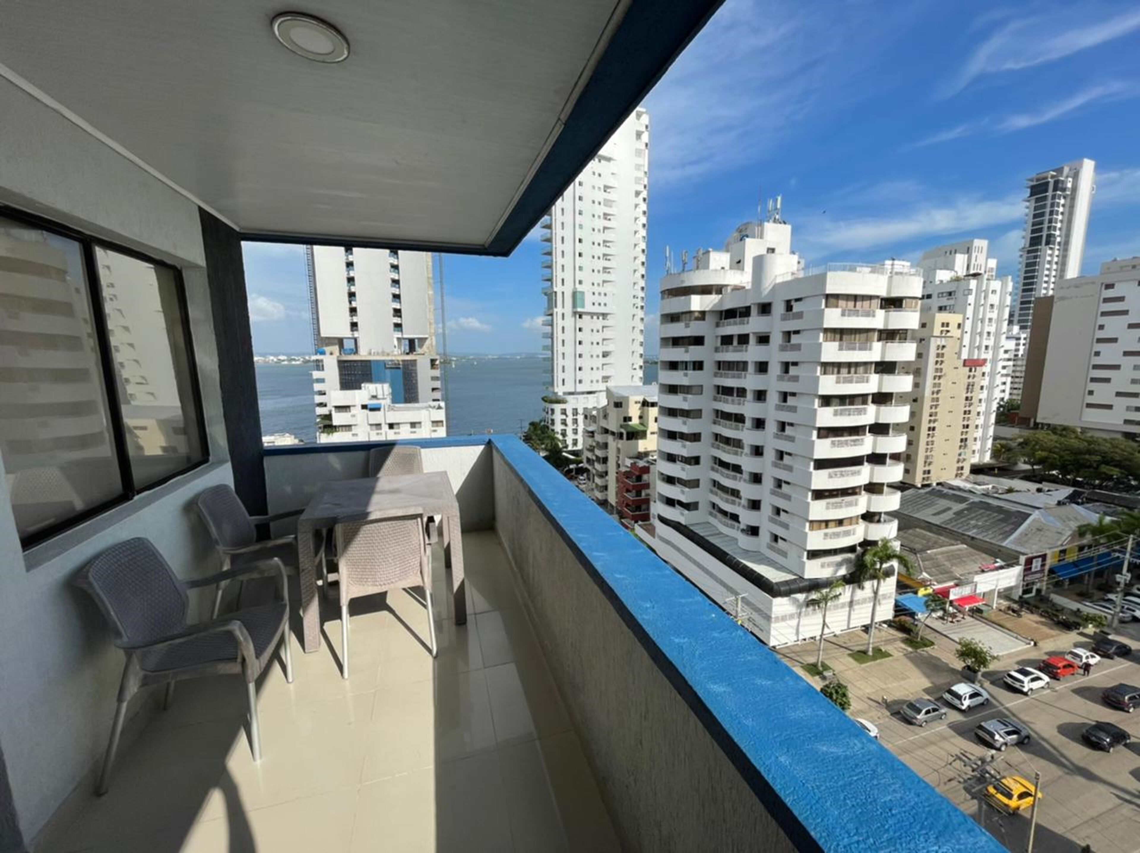 Een balkon met stoelen en uitzicht op een stadsbeeld met hoge gebouwen.