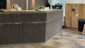 Un mostrador de recepción con diseño moderno, con listones verticales de madera e iluminación integrada.