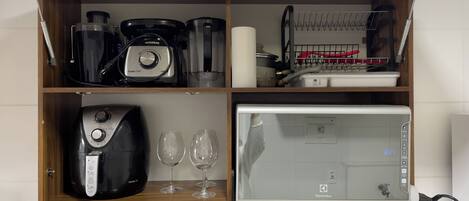 Eine Küche mit integriertem Mikrowellenherd, Kaffeemaschine und Toaster.