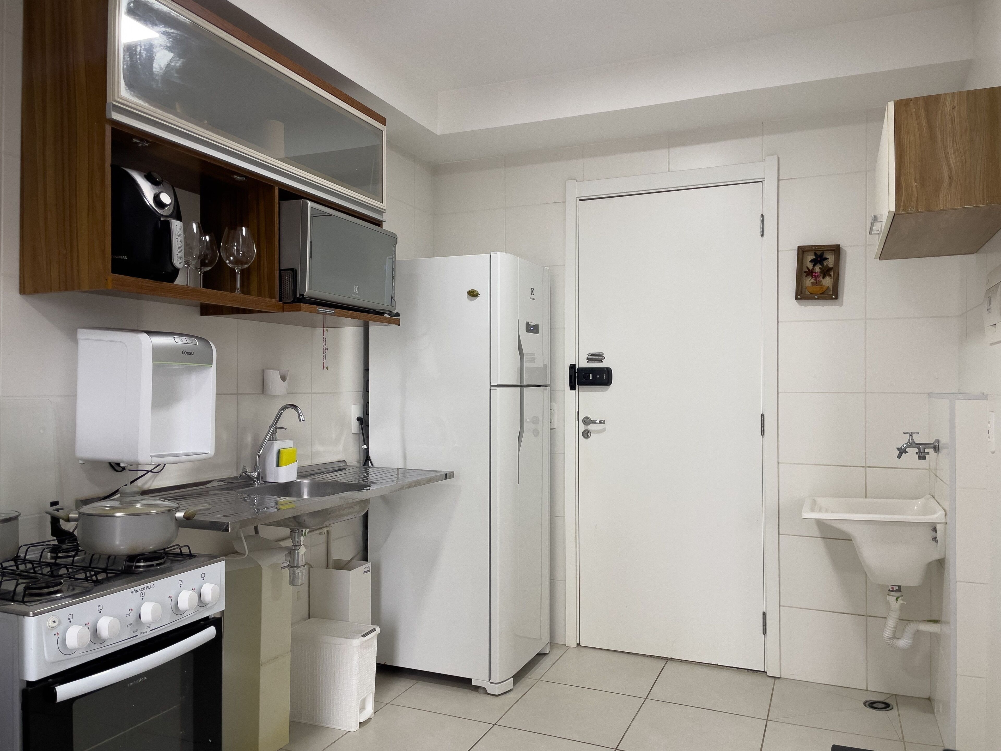 A modern kitchen with a stove, sink, refrigerator, and microwave.