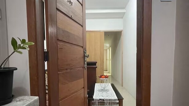 A hallway with a wooden door, a potted plant, and a table with a white tablecloth. - SuhcasaCopacabana 50 Ocean View (Rio de Janeiro)