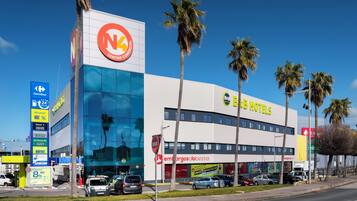 Un edificio comercial con un gran letrero que dice '4 CENTRO COMMERCIAL' y 'G4 HOTELS'.