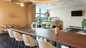 Un comedor moderno con una larga mesa de madera, sillas blancas y un abanico decorativo.