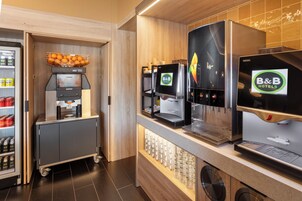 Cocina de un hotel B&B con cafetera, dispensador de bebidas y refrigerador para bebidas.