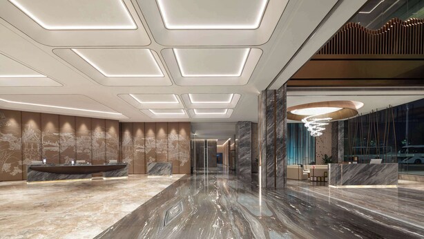 Um hall moderno com piso de mármore, balcão de recepção e uma ampla área de estar.