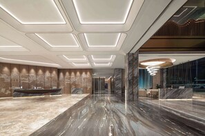 A modern lobby with a marble floor, a reception desk, and a large seating area. - Wyndham Xishuangbanna Qingquan (Xishuangbanna Dai)