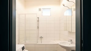 A modern bathroom with a shower, toilet, and sink. - Close to City Center - Affordable Private Rooms with TV (Vienna)