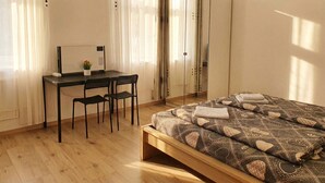 A bedroom with a bed, a desk, two chairs, a wardrobe, and a window with curtains. - Close to City Center - Affordable Private Rooms with TV (Vienna)