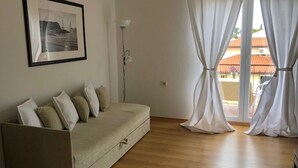 A minimalist living room with a sofa, a framed picture, and sheer curtains. - Casa Monte Mulini (Rovinj)