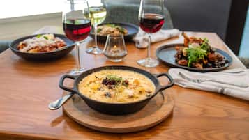 Una mesa de comedor con varios platos y copas de vino.