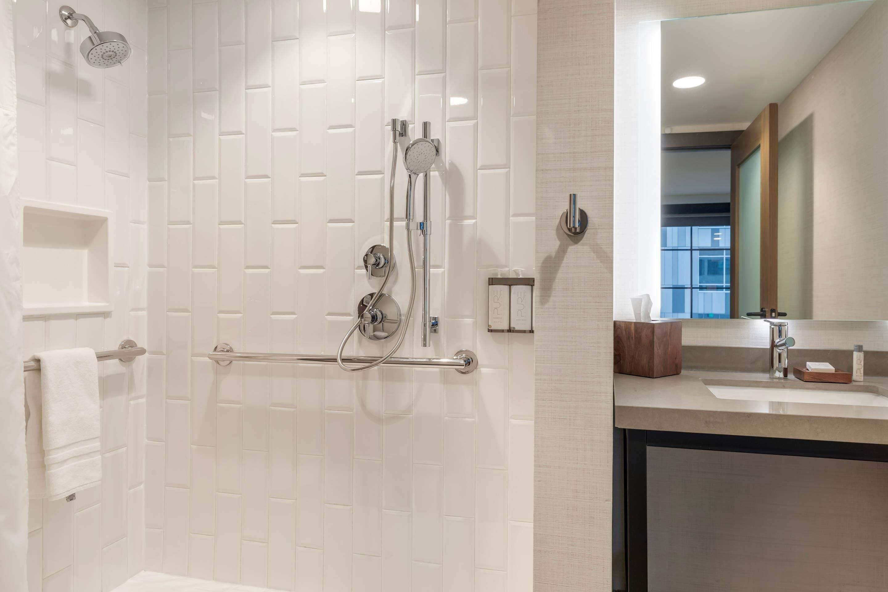 Une salle de bain moderne avec une douche à l’italienne, un meuble-lavabo et un miroir.