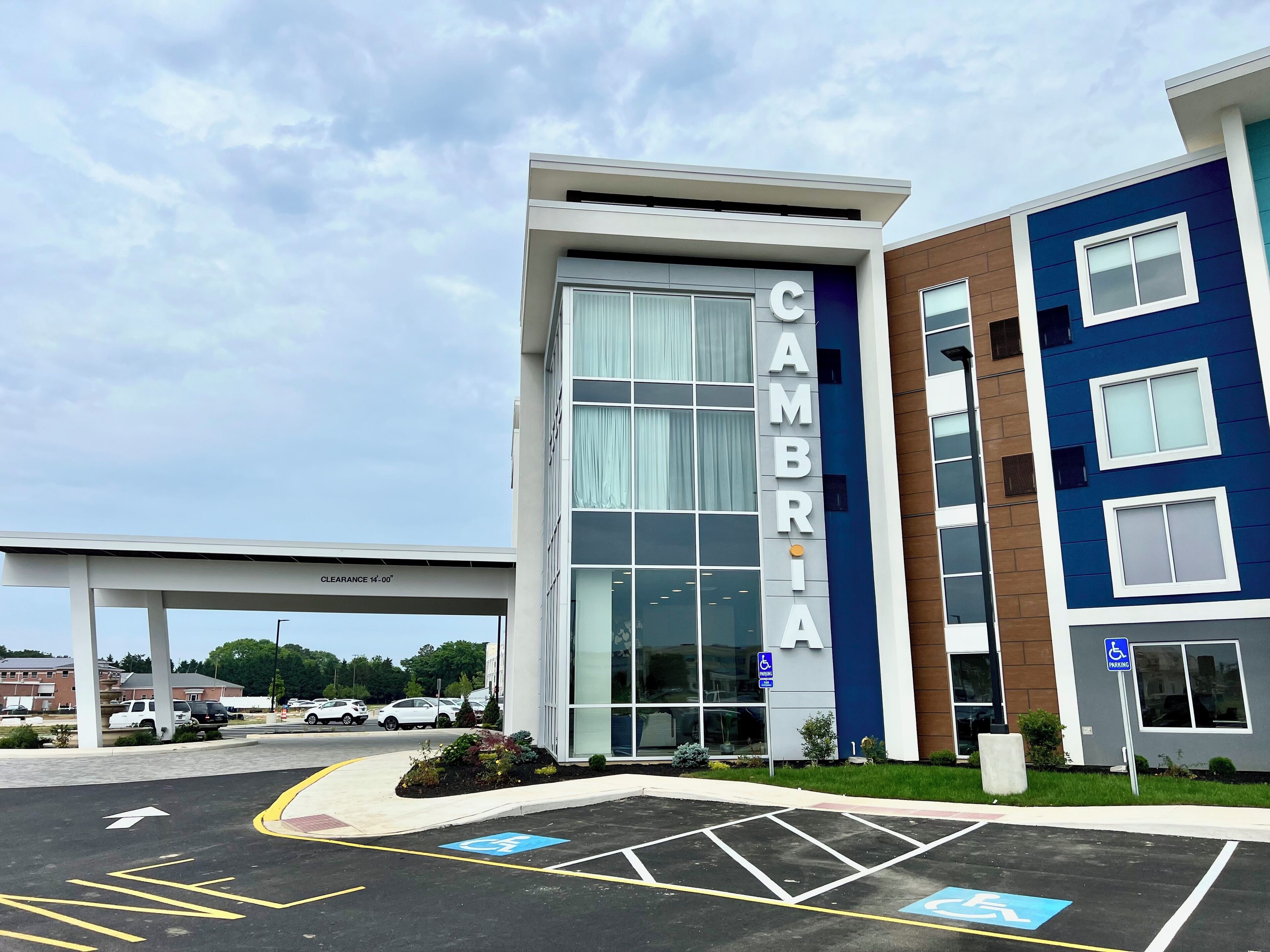 A modern building with a large glass entrance and the name "CAMBRIA" displayed prominently.