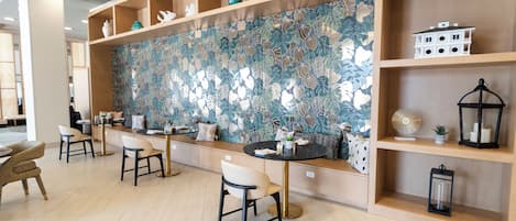 Um interior moderno com uma parede estampada com flores, prateleiras de madeira e áreas de estar.