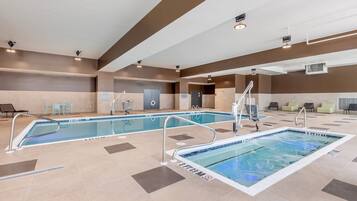 Une piscine d’hôtel divisée en deux zones distinctes, un espace détente avec des fauteuils et un panneau indiquant qu’il est interdit de plonger.