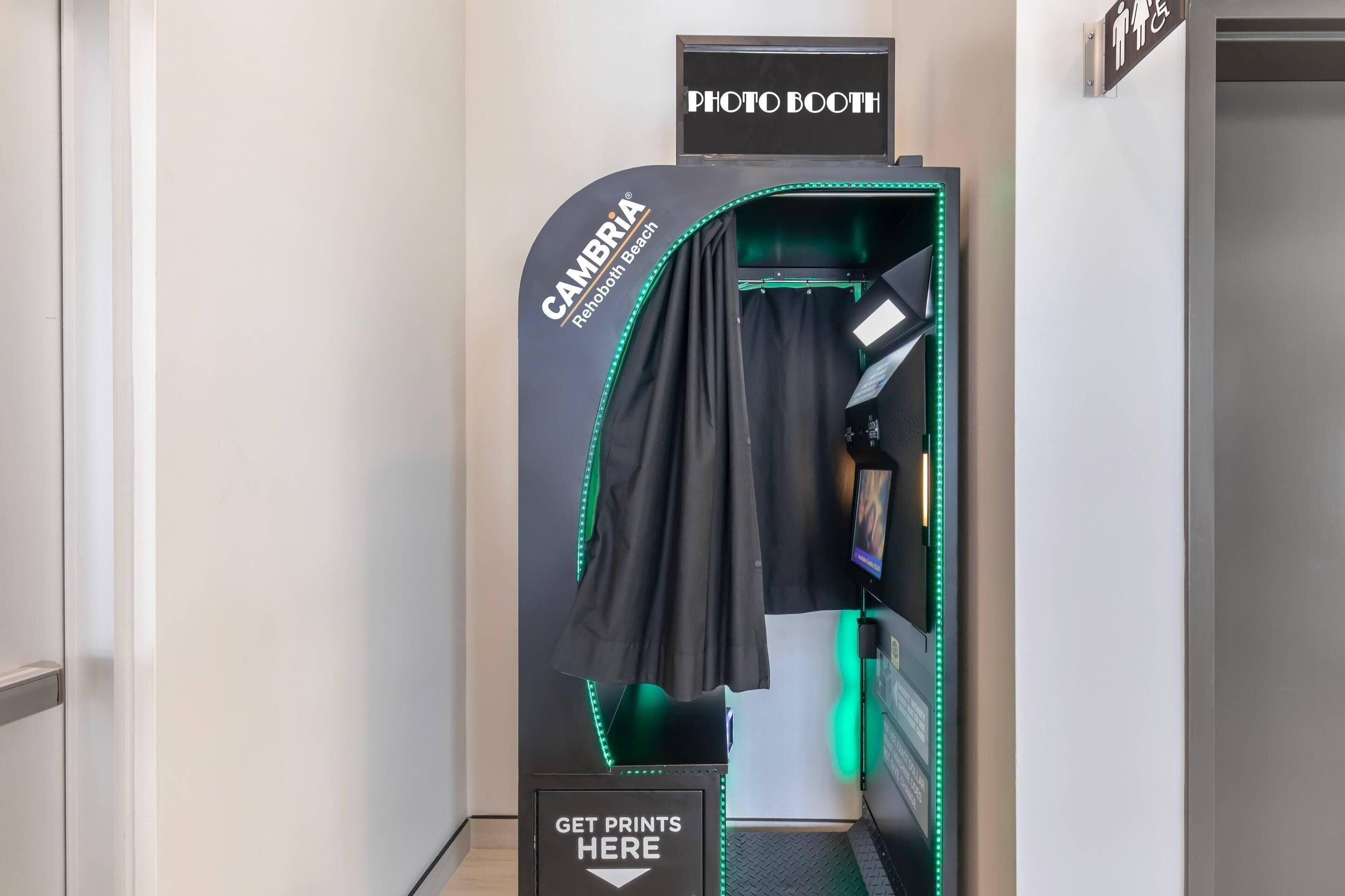 A photo booth with a sign indicating it is located at the 'CAMBRIA Rehoboth Beach' hotel.