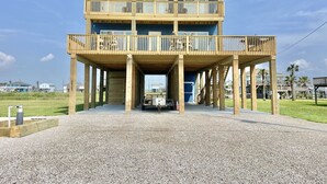 A two-story building with a wooden deck and a covered entrance.