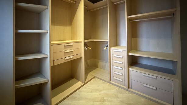 Un armario vestidor con amplios estantes, cajones y espacio para colgar.
