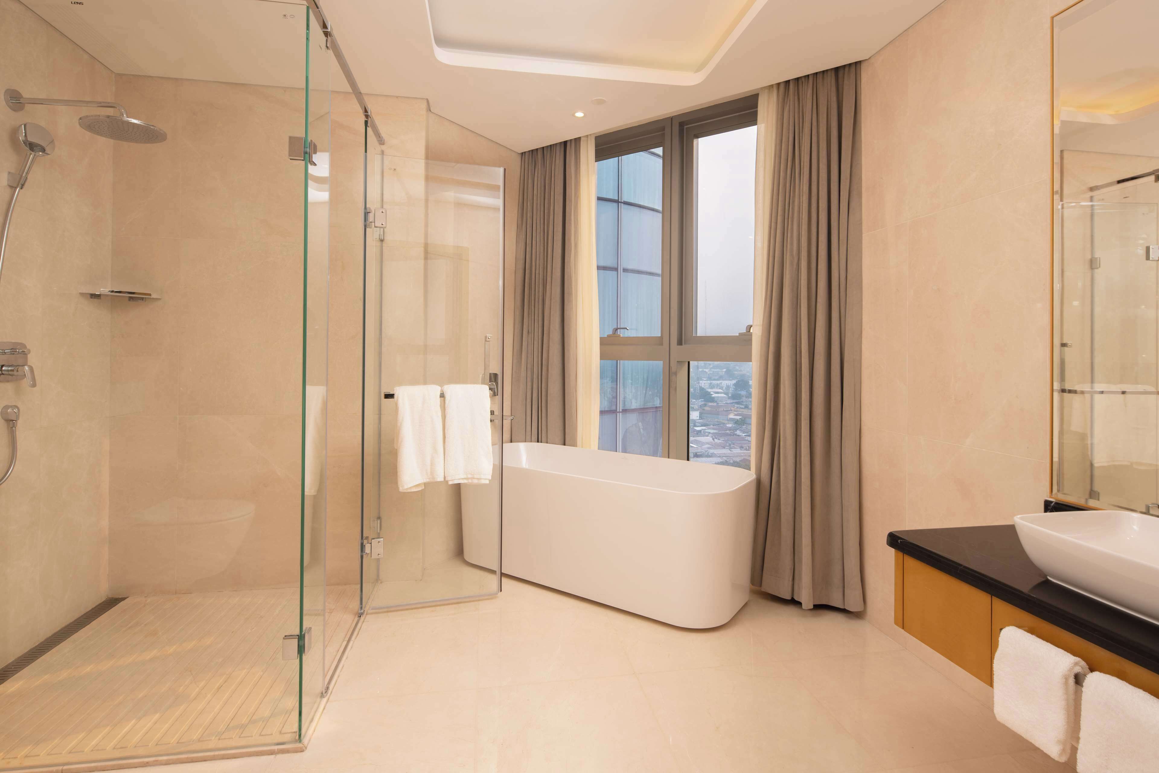 Ein modernes Badezimmer mit einer Glasdusche, einer freistehenden Badewanne und einem großen Spiegel.