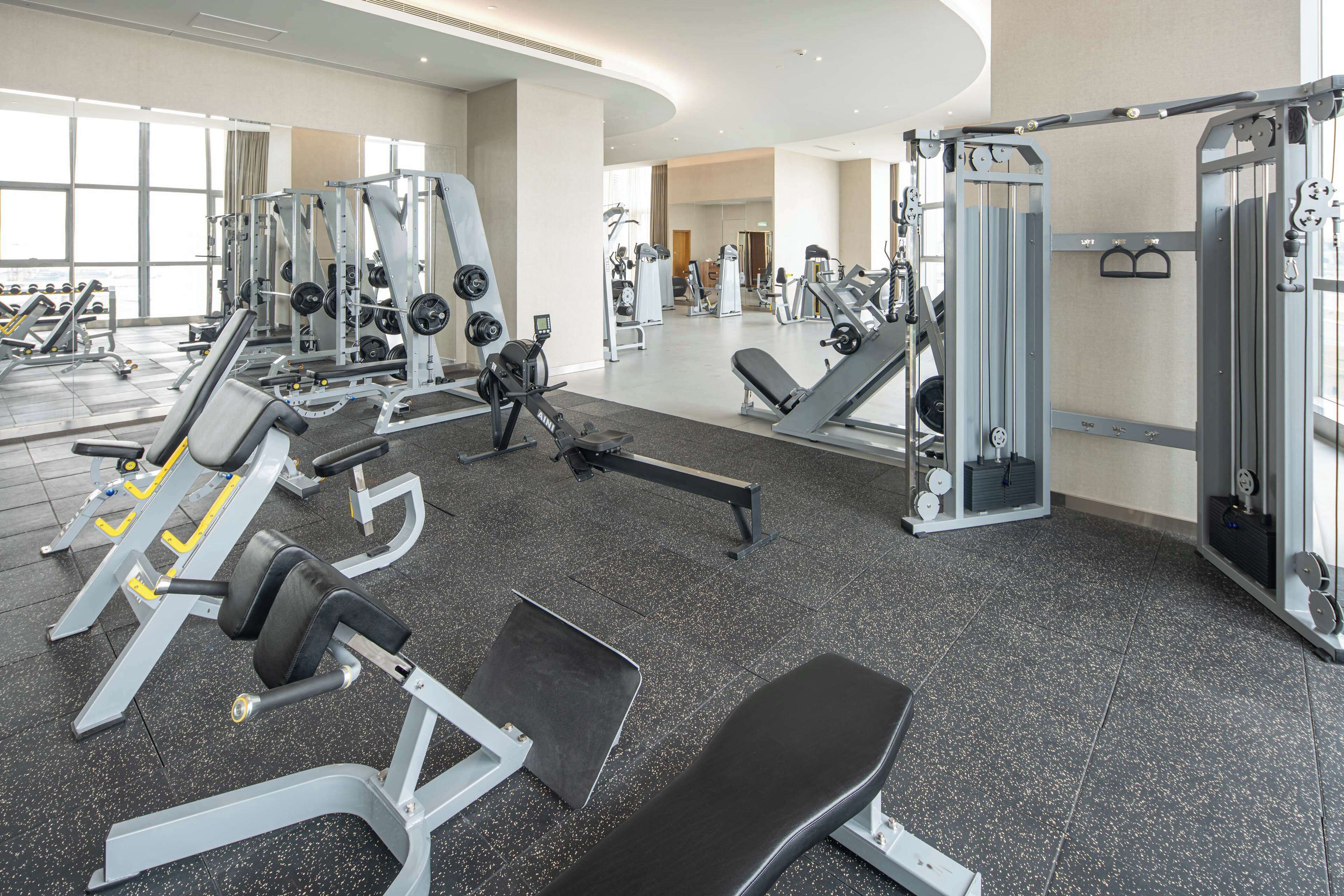 A gym with various exercise equipment, including weight machines and benches.