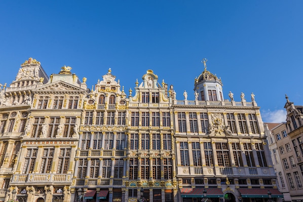 Un edificio imponente y ornamentado de arquitectura clásica, con amplias ventanas y estatuas.