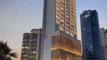 A tall hotel with a prominent 'Hampton' sign, featuring a modern glass facade and multiple floors.