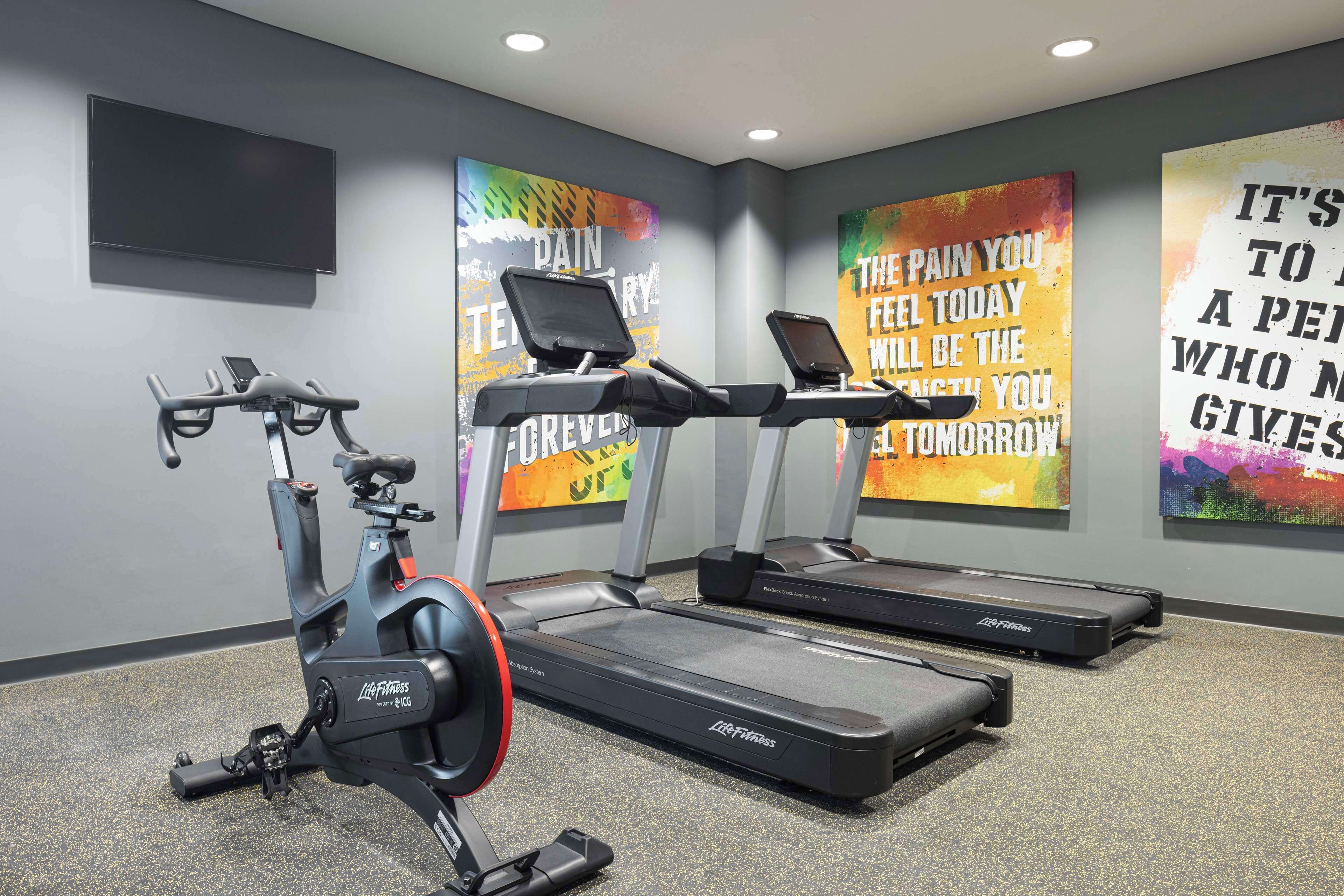 A modern gym with treadmills, an elliptical, and a stationary bike.